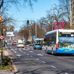 Korytarz miejski z ruchem ulicznym, autobusem i samochodami. Znaki drogowe ostrzegają przed wyjazdem.