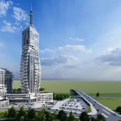 Nowoczesny kompleks budynków z najwyższym budynkiem w Polsce, otoczony zielenią i drogą z mostem.