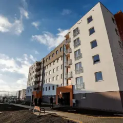 Nowe bloki mieszkalne, jeden z pomarańczową elewacją. Zastanawiasz się, co to znaczy, gdy ktoś chce odstąpić mieszkanie TBS?