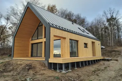 Nowoczesny dom 70m2 z drewnianą elewacją i dużymi oknami. Poznaj koszt budowy domu 70m2 pod klucz.