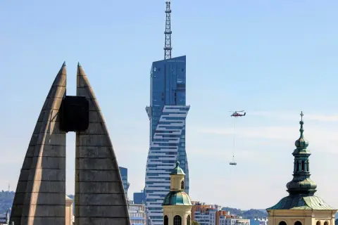 Widok na najwyższy budynek mieszkalny w Polsce, z helikopterem dostarczającym ładunek.