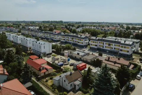 Nowe bloki mieszkalne w budowie, otoczone starszą zabudową i zielenią. To obraz rozwoju tej największej dzielnicy Warszawy.
