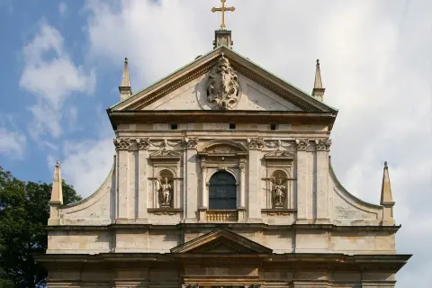 Majestatyczna fasada kościoła, przykład bogatej architektury baroku, z rzeźbami i zdobieniami.