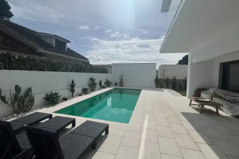 Nowoczesny basen z leżakami i kaktusami, idealny na tanie domy w Portugalii nad morzem.