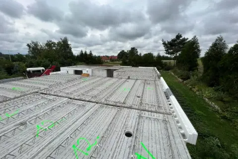 Gotowy do zalania strop filigran, z zielonymi oznaczeniami i elementami szalunku traconego.