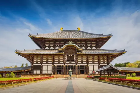 Wielka, drewniana budowla z wieloma dachami, przypominająca architekturą pagodę. To świątynia Todai-ji w Japonii.