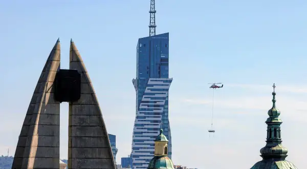 Widok na najwyższy budynek mieszkalny w Polsce, z helikopterem dostarczającym ładunek.
