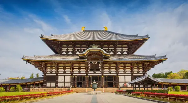 Wielka, drewniana budowla z wieloma dachami, przypominająca architekturą pagodę. To świątynia Todai-ji w Japonii.