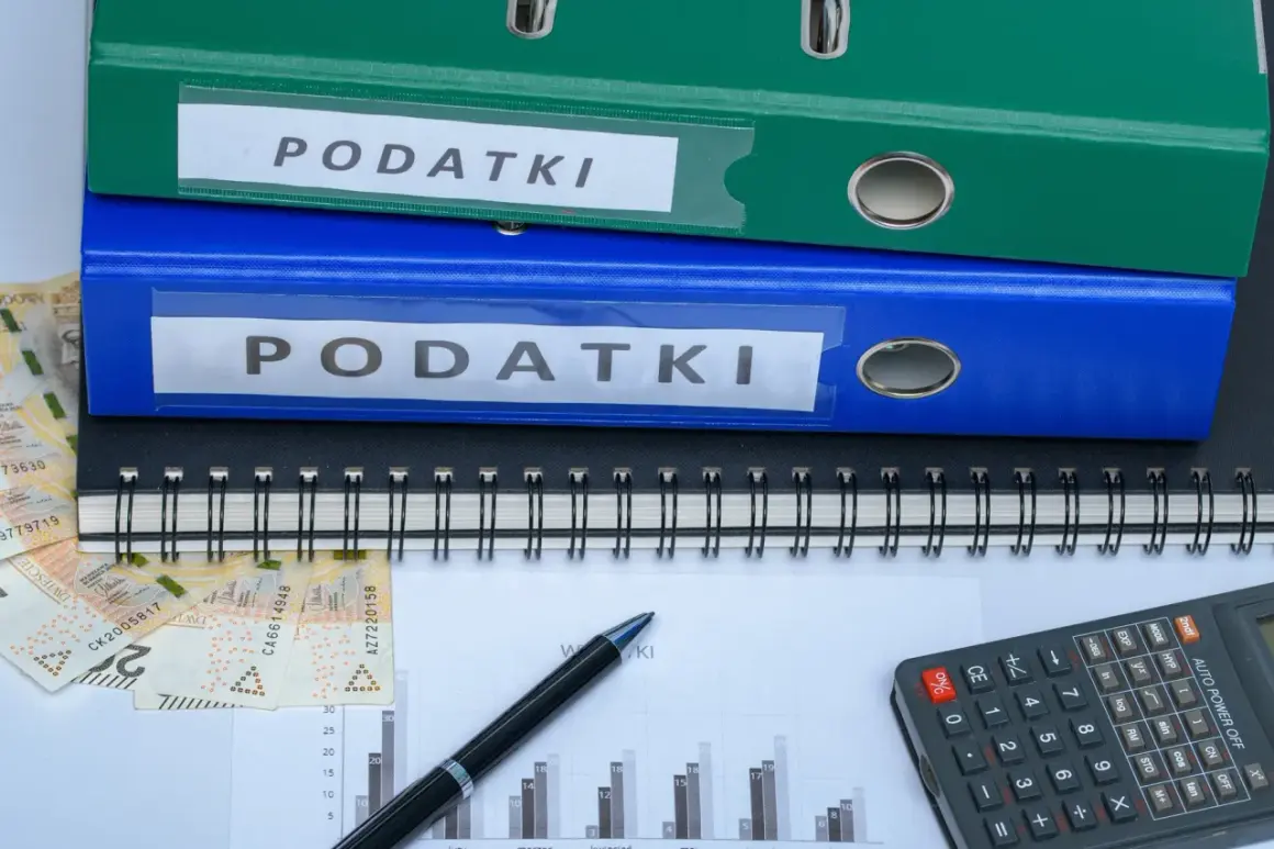 Dwa segregator "PODATKI", zeszyt, pieniądze i kalkulator. Jak zmniejszyć podatek za budynki gospodarcze?