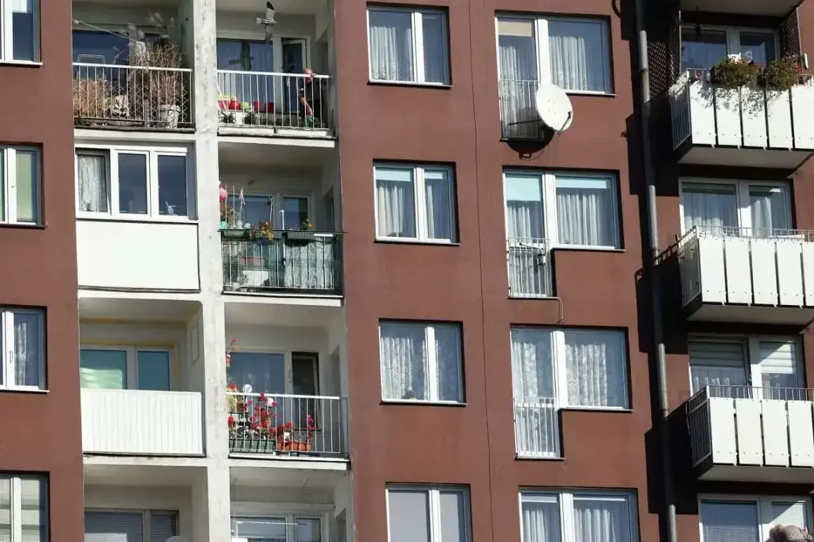 Blok mieszkalny z balkonami, na których widać rośliny i antenę satelitarną. Czy mieszkanie TBS można wykupić?