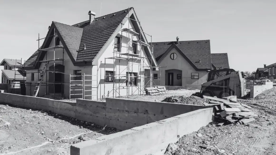 Domy w budowie, rusztowania, koparka i betonowe fundamenty. Wkrótce będzie pozwolenie na budowę i nowe domy.
