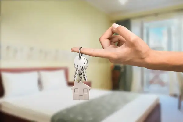 Klucze z breloczkiem w kształcie domu, symbolizujące nowy dom lub inwestycję w najem instytucjonalny.