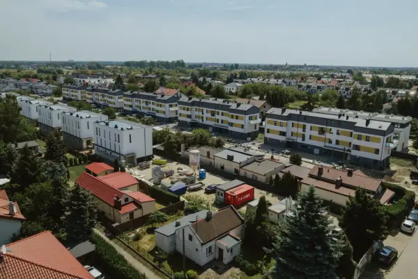 Nowe bloki mieszkalne w budowie, otoczone starszą zabudową i zielenią. To obraz rozwoju tej największej dzielnicy Warszawy.