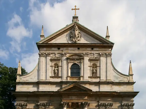 Majestatyczna fasada kościoła, przykład bogatej architektury baroku, z rzeźbami i zdobieniami.