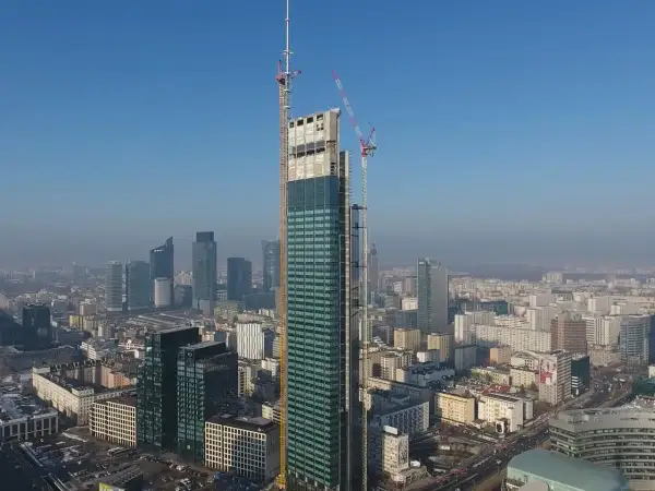 Varso Tower w budowie, z widokiem na warszawską panoramę. Trwają prace nad kolejnymi piętrami tego imponującego wieżowca.