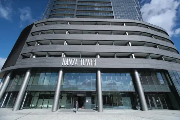 Nowoczesny budynek Hanza Tower z przeszklonym parterem i tarasami.