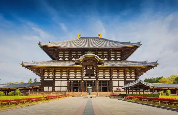 Wielka, drewniana budowla z wieloma dachami, przypominająca architekturą pagodę. To świątynia Todai-ji w Japonii.